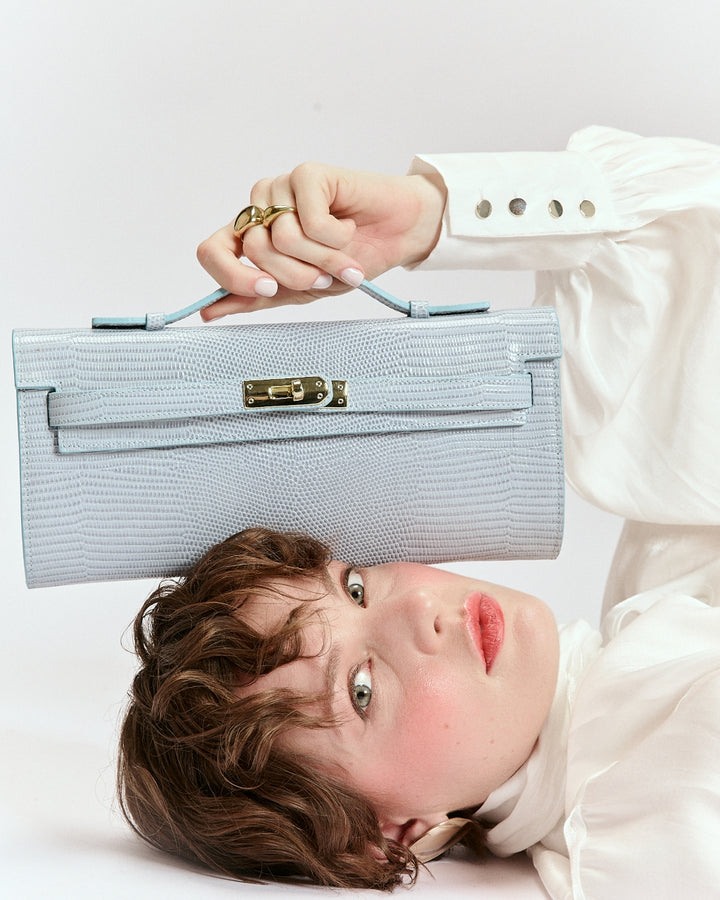 Jade Tejus clutch in leather featuring a secure closure, a retractable handle, and a detachable, adjustable shoulder strap.